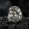 Load image into Gallery viewer, Oxidized Hephaestus signet ring close-up on volcanic rock, detailed Greek forge god portrait and helmet relief