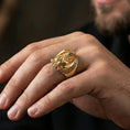 Load image into Gallery viewer, Gold plated griffin guardian ring worn on finger, statement mythology jewelry inspired by ancient traveler protection symbols, premium lifestyle close-up