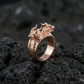 Load image into Gallery viewer, Rose gold plated twin dragons ring showcasing double dragon head motif and detailed scale texture, sharp close-up product photography on volcanic rock