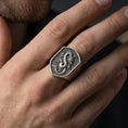 Load image into Gallery viewer, Oxidized sterling silver Chinese dragon shield signet ring worn on finger, bold dragon emblem and textured signet face, masculine lifestyle hand shot