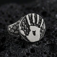 Load image into Gallery viewer, Oxidized sterling silver assassin handprint signet ring with skull band texture, dark fantasy statement jewelry on black volcanic rock