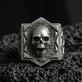 Load image into Gallery viewer, Oxidized sterling silver skull signet ring on black volcanic stone, brickwork background, gothic statement jewelry