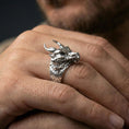 Load image into Gallery viewer, Polished sterling silver horned dragon ring on a human finger, sculpted dragon scales and horns, fantasy jewelry