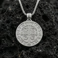 Load image into Gallery viewer, Polished sterling silver St. Benedict medal necklace on black volcanic stone, sacred Christian devotional pendant, braided chain