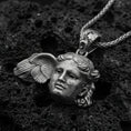 Load image into Gallery viewer, Oxidized sterling silver Hypnos pendant on textured volcanic rock, serene Greek god face with wing detail, macro studio shot