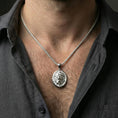 Load image into Gallery viewer, Polished silver lion head oval pendant necklace worn on neck, close lifestyle crop, clear mane texture and raised lion relief