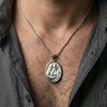 Load image into Gallery viewer, Polished silver Holy Family medallion necklace worn on neck, close lifestyle crop, clear family relief and oval frame details