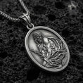 Load image into Gallery viewer, Oxidized sterling silver Jesus Christ oval medal on textured volcanic rock, detailed religious relief with crown of thorns, macro studio shot