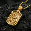 Load image into Gallery viewer, Gold plated Saint Christopher pendant on porous volcanic rock backdrop, rectangular devotional medal with child and staff relief, high-contrast lighting