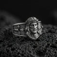 Load image into Gallery viewer, Oxidized sterling silver Jesus Christ ring on volcanic rock, crowned Christ face relief, cross motif band, macro photo