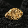 Load image into Gallery viewer, Gold plated Good Shepherd signet ring on dark volcanic rock, Jesus holding lamb relief in warm tone with crisp sculpted edges