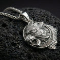 Load image into Gallery viewer, Polished silver Norse wolf Fenrir pendant displayed on volcanic stone background with sharp carved fur texture