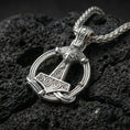 Load image into Gallery viewer, Polished silver Viking Mjölnir pendant necklace displayed on volcanic stone background with bold hammered texture