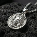 Load image into Gallery viewer, Polished silver Medusa Greek mythology pendant displayed on volcanic stone background with sharp sculpted facial detail