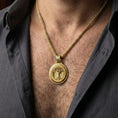 Load image into Gallery viewer, Gold plated tree of life Yggdrasil pendant necklace worn by man as meaningful mythological statement jewelry