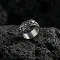Load image into Gallery viewer, Oxidized geometric faceted band ring photographed on volcanic rock with sharp pyramid-cut texture and industrial masculine finish