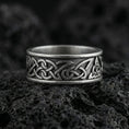 Load image into Gallery viewer, Oxidized Celtic knot band ring photographed on volcanic rock with interlaced Viking braid engraving and dark antique contrast