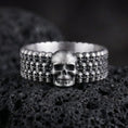 Load image into Gallery viewer, Oxidized faceted geometric band ring photographed on volcanic rock with sharp prism edges and matte industrial finish