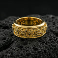 Load image into Gallery viewer, Gold plated Greek history spinner ring displayed on volcanic rock with museum-style carved crowd frieze and premium antique look