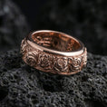 Load image into Gallery viewer, Rose gold plated floral spinner ring on volcanic rock emphasizing engraved rose motifs, elegant warmth, and refined anniversary gift appeal