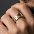 Load image into Gallery viewer, Gold plated wave motif band ring worn by man as a bold anniversary statement ring with ocean-current inspired engraving