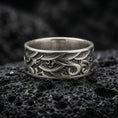 Load image into Gallery viewer, Oxidized sterling silver wave pattern band ring photographed on volcanic rock, featuring deep engraved swirls and vintage geometric texture