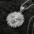 Load image into Gallery viewer, Polished silver Helios pendant necklace on porous volcanic stone, detailed sun god face with sharp sunburst rays
