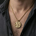Load image into Gallery viewer, Gold plated ankh necklace worn on neck, Egyptian ankh pendant with Eye of Providence centerpiece and ornate background texture