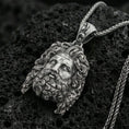 Load image into Gallery viewer, Oxidized sterling silver deity head pendant on volcanic rock, detailed sculpted hair and beard, macro studio shot