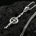 Load image into Gallery viewer, Polished silver ankh spear necklace on volcanic rock, clean reflective finish and sharp geometric lines, close-up