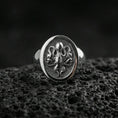 Load image into Gallery viewer, Polished silver octopus signet ring on volcanic rock, detailed sea creature octopus relief in circular bezel, clean close-up jewelry shot