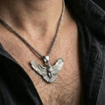 Load image into Gallery viewer, Polished silver owl pendant on braided chain worn on neck, natural lifestyle framing, detailed wings visible