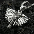 Load image into Gallery viewer, Polished silver elephant necklace pendant on black volcanic stone background, crisp sculpted textures, high-end product shot