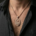 Load image into Gallery viewer, Rose gold plated Saint Joseph pendant necklace worn on neck, lifestyle composition with dark clothing, crisp oval medallion silhouette