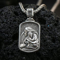 Load image into Gallery viewer, Polished silver Mary and Child necklace pendant on black volcanic stone background, crisp rectangular frame and drapery details, high-end product shot