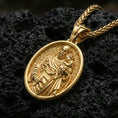 Load image into Gallery viewer, Gold plated Saint Joseph medal pendant displayed on porous volcanic rock surface, close-up studio composition, detailed saint figure and border