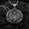 Load image into Gallery viewer, Oxidized Saint Uriel pendant on textured volcanic rock, macro close-up, angel warrior medallion detail, premium studio lighting