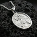 Load image into Gallery viewer, Polished silver Sacred Heart Jesus necklace pendant on black volcanic stone background, crisp halo and heart rays, high-end product shot