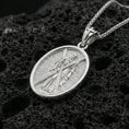 Load image into Gallery viewer, Polished silver Saint Andrew oval medallion pendant on black volcanic stone, crisp edge frame and textured background, luxury product photo