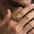 Load image into Gallery viewer, Gold plated octagon lion signet ring worn on finger, premium lifestyle wear photo featuring bold lion crest face and ornate band detailing