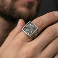 Load image into Gallery viewer, 925 sterling silver crane signet ring worn on a finger, oxidized finish showing deep contrast in the crane engraving and textured panel