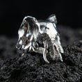 Load image into Gallery viewer, Polished silver elephant head ring on volcanic rock, macro product photo highlighting trunk and tusk details