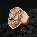 Load image into Gallery viewer, Rose gold plated wolf signet ring on volcanic rock, sharp macro product photo showcasing the shield face and detailed wolf portrait