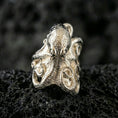 Load image into Gallery viewer, Polished silver octopus ring on volcanic rock surface, close-up highlighting the sculpted head, wrapped tentacles, and clean metal contours