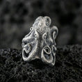 Load image into Gallery viewer, Oxidized sterling silver octopus ring on textured volcanic rock, macro close-up showing tentacle curls and speckled sea-creature texture