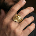 Load image into Gallery viewer, Gold plated owl ring worn on finger, lifestyle wear shot emphasizing the bold bird silhouette and layered feather details