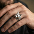 Load image into Gallery viewer, Polished silver lynx head ring on finger, natural hand pose highlighting the pointed ears, whisker pad detail, and bold animal silhouette