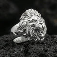 Load image into Gallery viewer, Polished silver lion head ring on volcanic stone, sharp mane carving and bold sculpted face