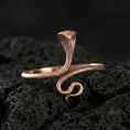 Load image into Gallery viewer, Rose gold plated cobra ring on volcanic rock, sharp macro product photo showcasing the hooded snake pose and intricate scale detailing