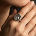 Load image into Gallery viewer, Oxidized horse signet ring worn on finger, lifestyle close-up focusing on the round face and engraved stallion portrait with dark recessed texture